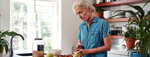 Image of woman cutting fruit in her kitchen